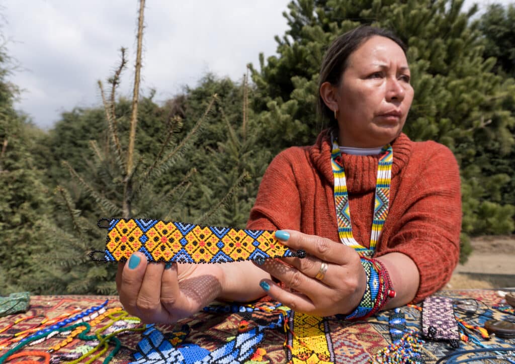 Female selling different decorative items and accessories - huichol art