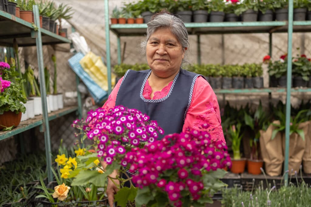 Friendly Hispanic female gardener in a nursery